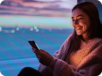 Man smiling while holding her phone