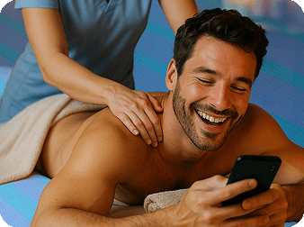 A man looking at his phone while receiving a massage