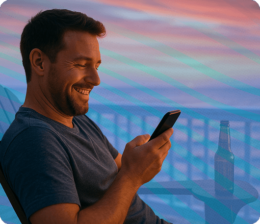 A man looking at his phone while relaxing on his patio